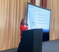 small chantalle presenting with mic and large screen